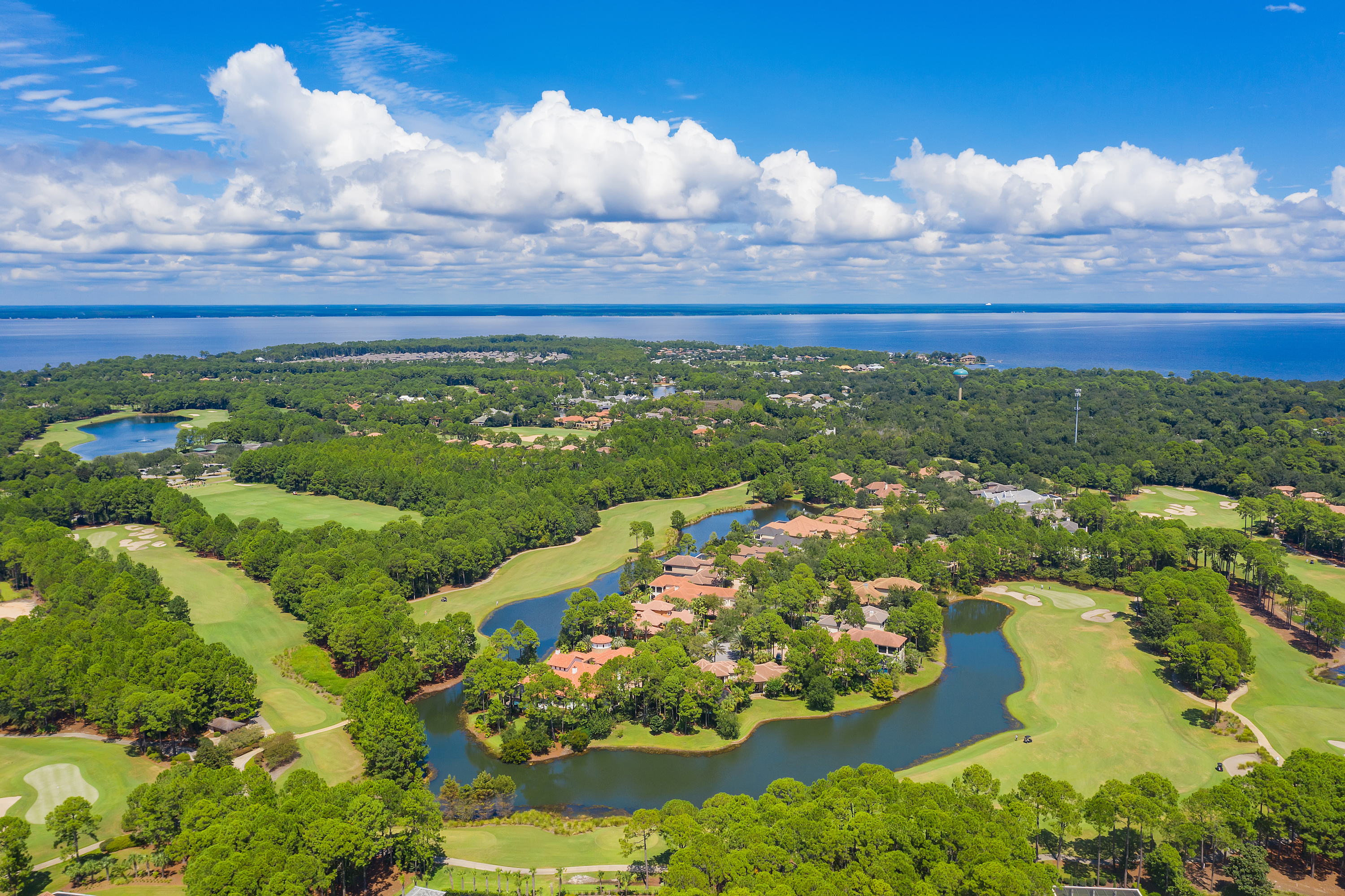 An aerial view of Sandestin homes and golf course with Choctawhatchee Bay in the background on a sunny day